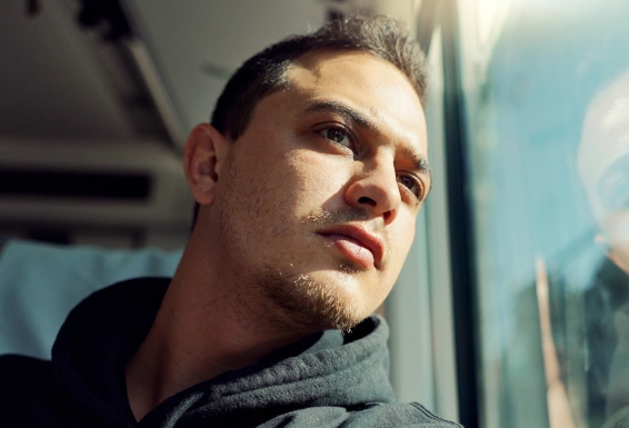 A man looking out the window of public transport.