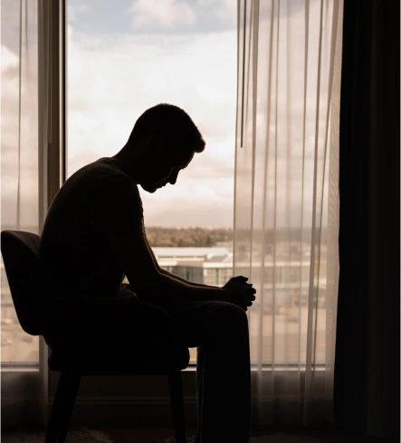 The silhouette of a seated man in depression.