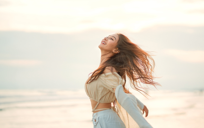 A happy girl by the sea.